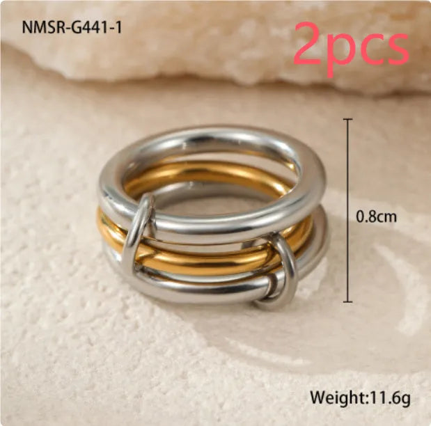 Stacked gold plated stainless steel ring set showing exaggerated design on a model's hand.