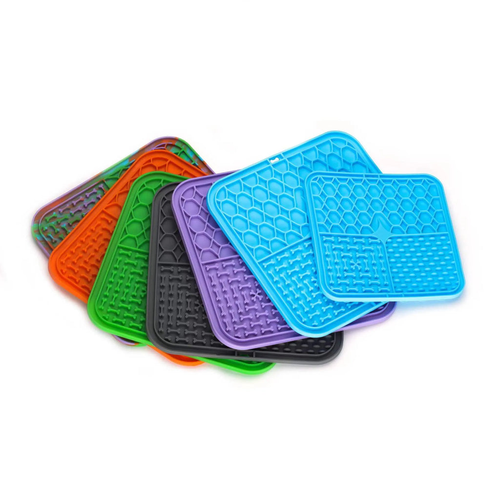 Silicone pet licking mat with suction cup on a tiled floor, featuring a slow food surface for dogs and cats