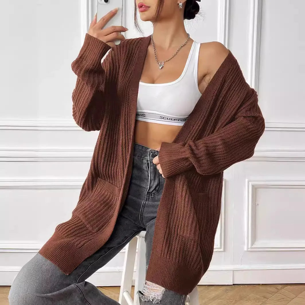 Women's dark green two-pocket acrylic cardigan sweater with loose fit and long sleeves
