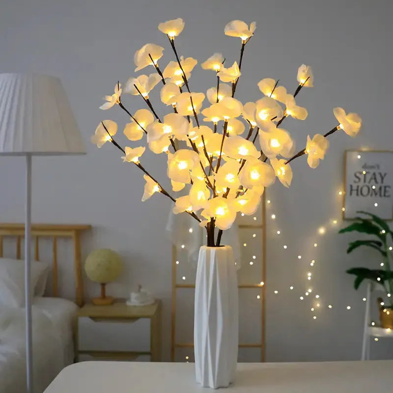 Pink LED phalaenopsis orchid branch decorative light, 65 cm tall, on a table.