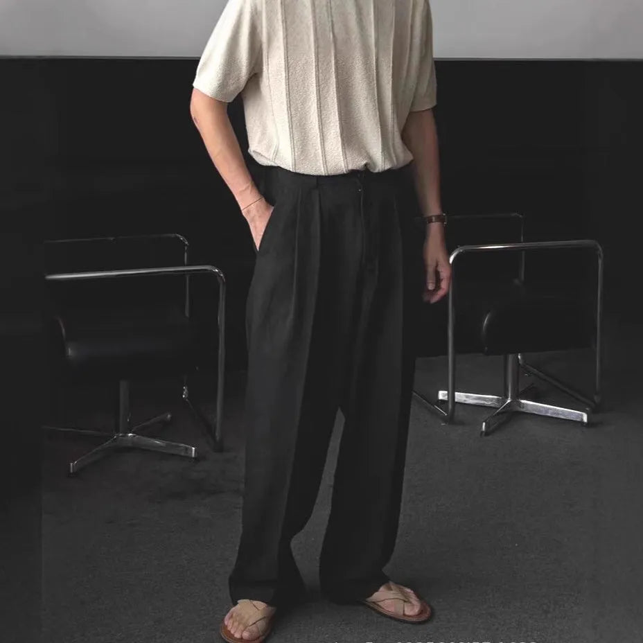 Men's lightweight apricot coloured wide-leg cotton linen trousers with a pencil leg opening on a hanger