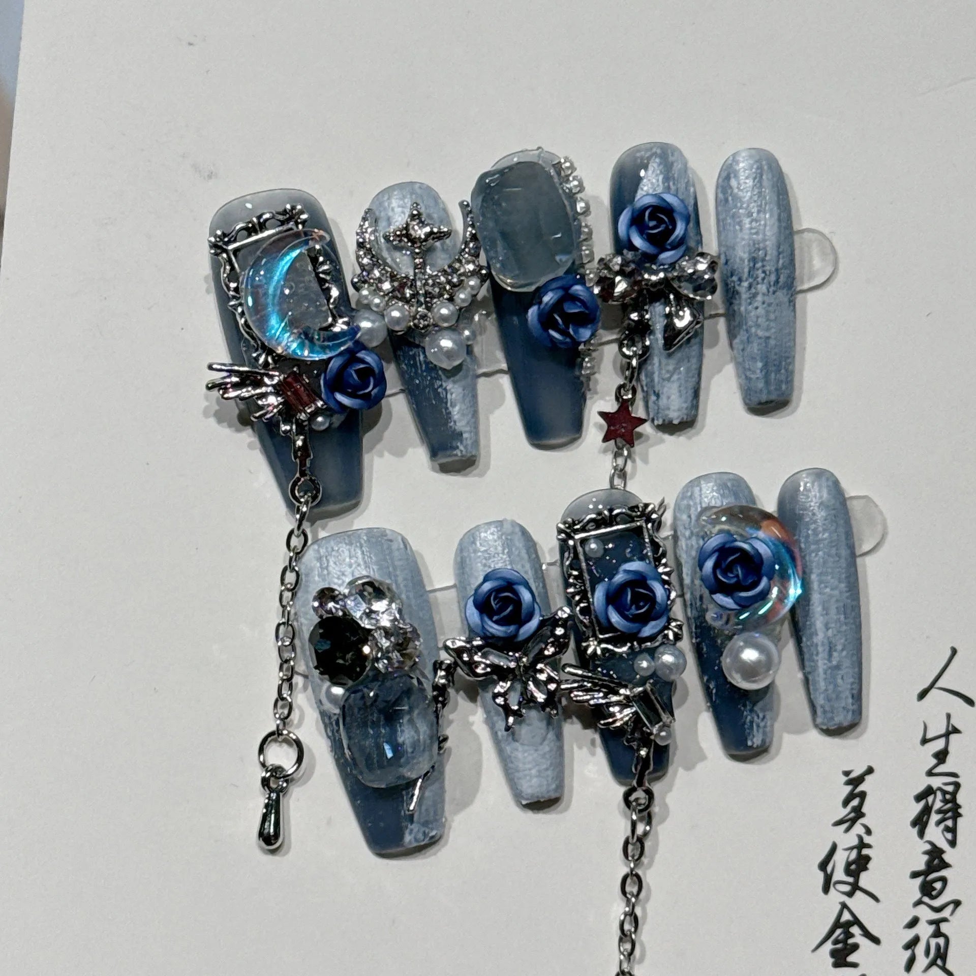 Women's ornate rose floral pattern manicure nails in heavy industry blue colour on a plastic armour suit.