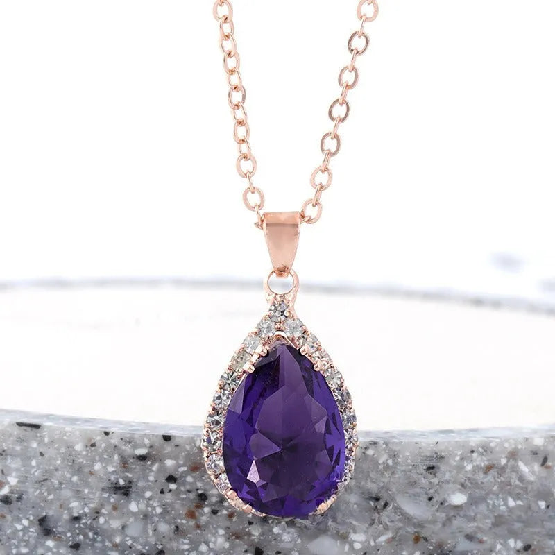 Pink water drop shaped rhinestone necklace with rose gold electroplated alloy pendant on white background