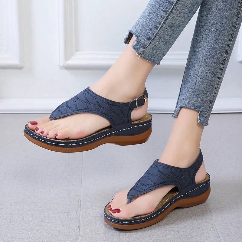Women's casual wedge heel flip flop sandals with an adjustable buckle strap in black.