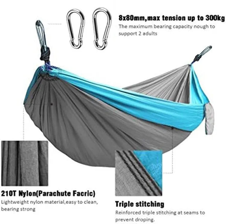 Blue parachute nylon camping hammock hanging between trees with 300kg capacity