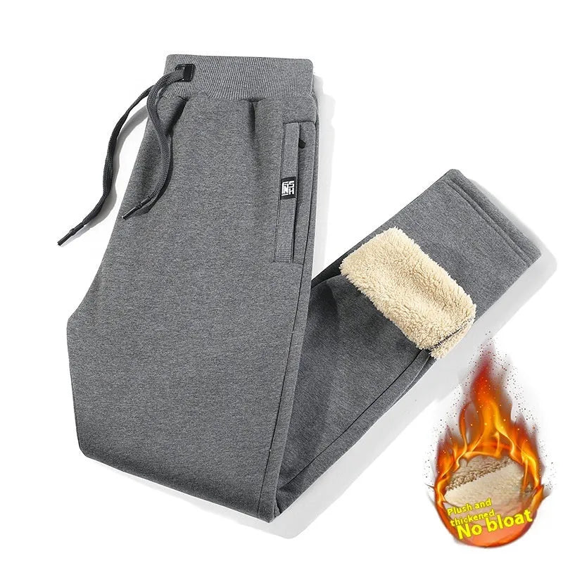 Man wearing grey fleece-lined cotton oversized track pants with a drawstring waistband.