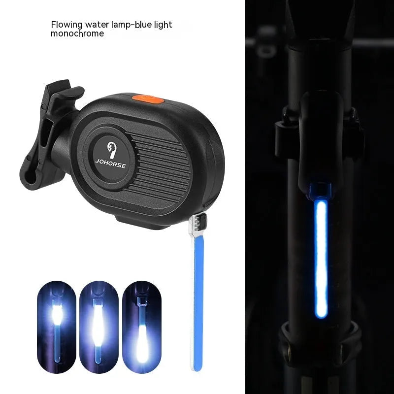 Bicycle rear safety taillight displaying a colourful running water or waterfall light effect on a black background.