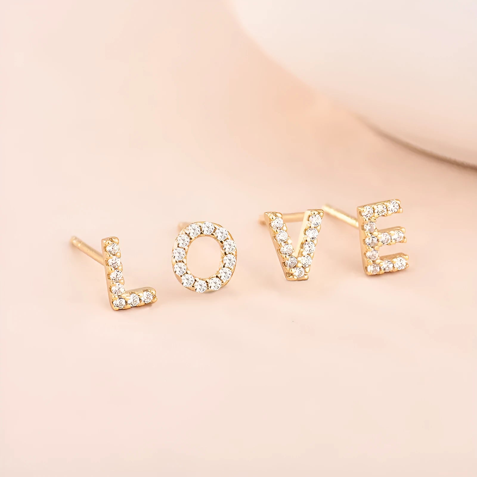 Gold-plated brass alphabet earring showing a single letter with zircon detail on a copper base.