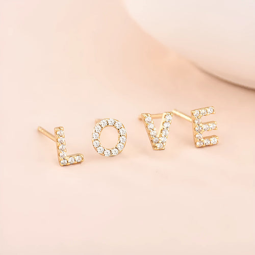 Gold-plated brass alphabet earring showing a single letter with zircon detail on a copper base.