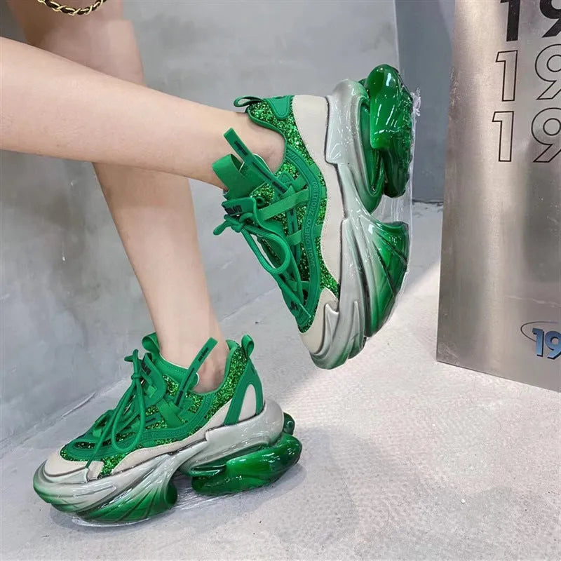 Women's green leather sports shoes with thick soles and cross-tie lacing on a white background.