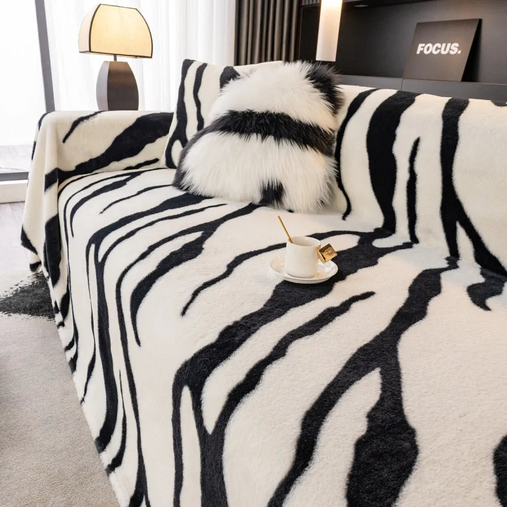 Thickened flannel zebra pattern sofa cover in caramel or black draping over a sofa with non-slip texture visible