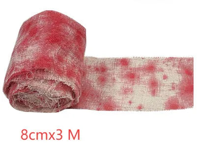 Roll of Halloween horror dyed gauze bandage in bloody red colour, shown with a loose end draped.