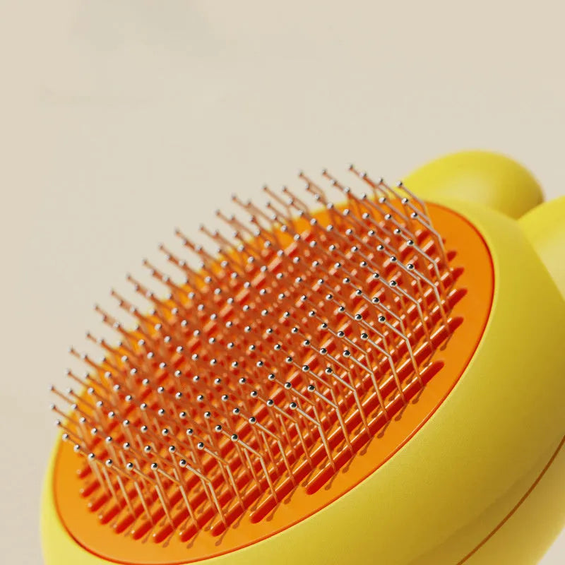 Green pet grooming brush with metal comb and release button on a non-slip handle