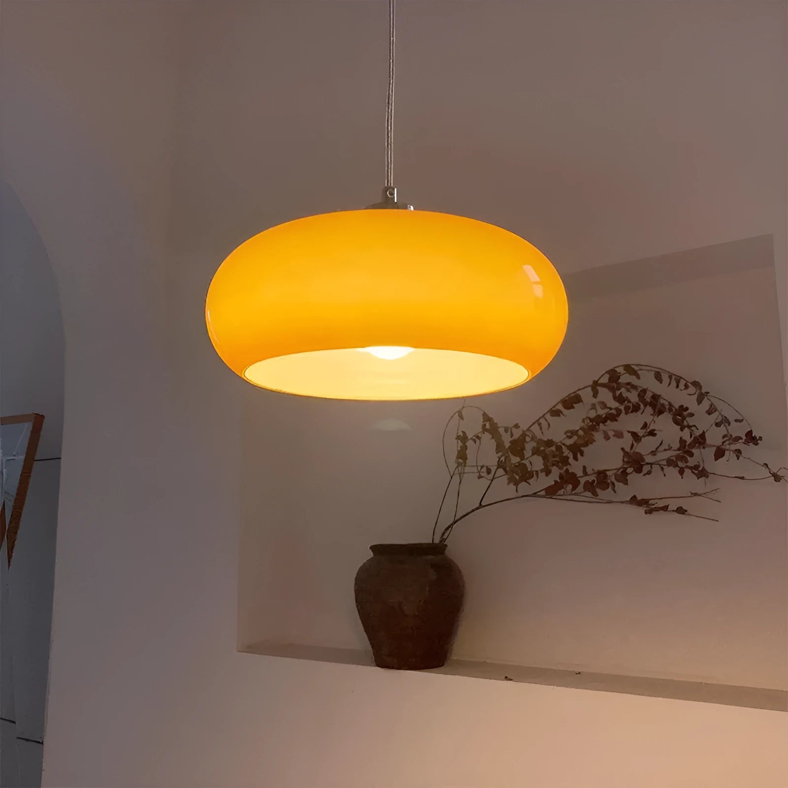 Three-headed Bauhaus pendant light with milky white glass egg tart shades hanging from a ceiling.