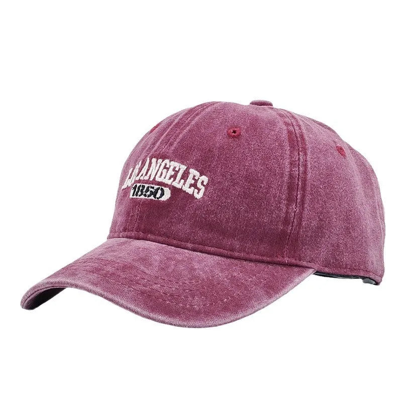 Retro washed distressed embroidered peaked cap with adjustable strap on a conical crown.