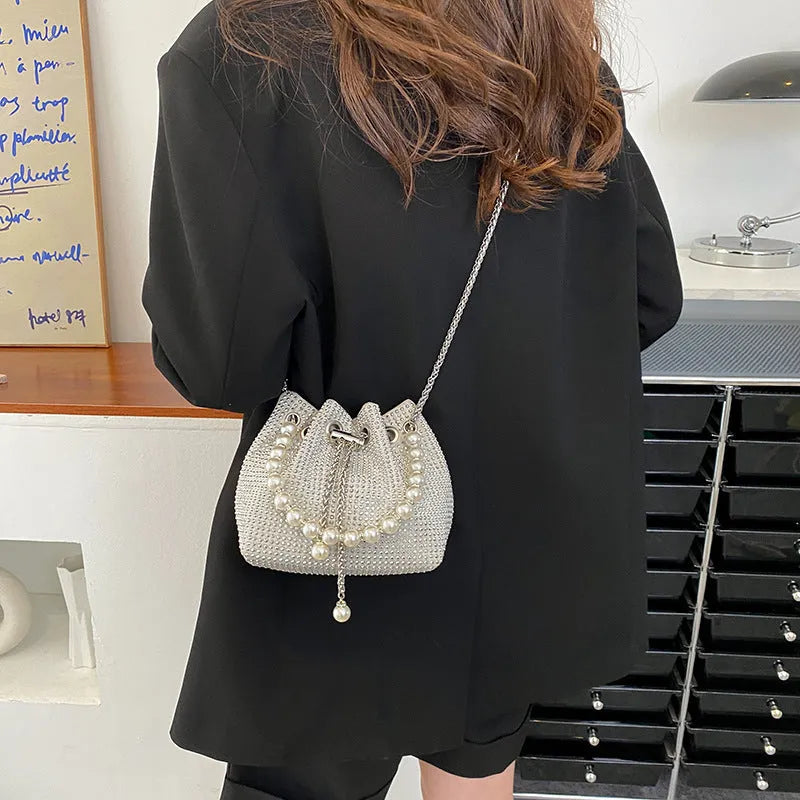 Women's soft PU light diamond decorated crossbody shoulder bag with chain strap in bucket shape.