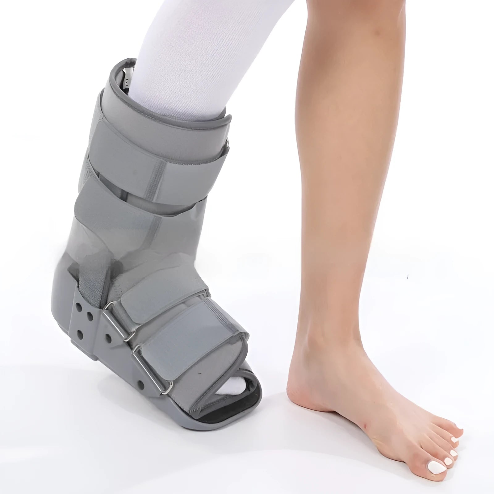 Grey Achilles tendon rehabilitation boot with aluminium side struts and a rubber sole, shown on a foot.