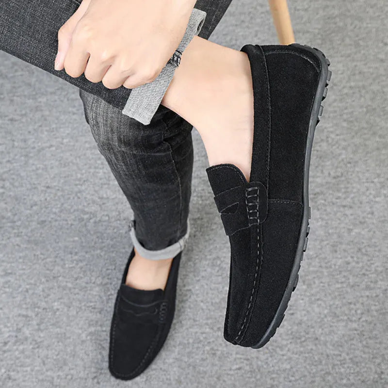 Men's solid colour suede leather slip-on loafers with a flat rubber sole.
