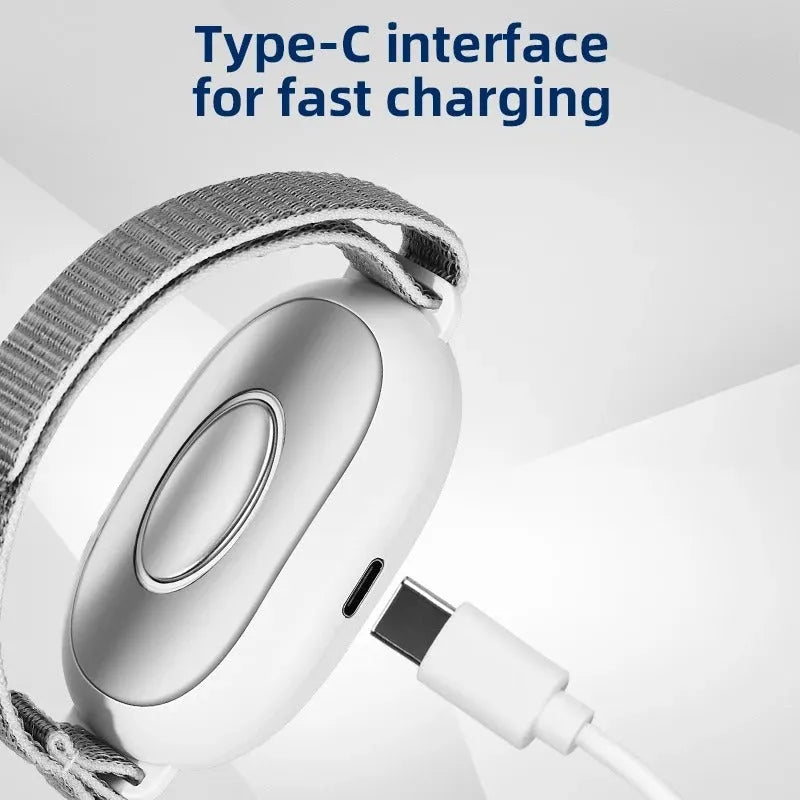 White handheld sleep aid device with remote control and wearable bracelet on charging cable