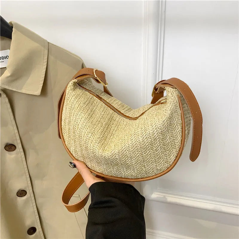 Women's straw woven crossbody bag showing knitted weaving texture and internal phone pocket