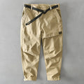 Men's khaki coloured loose-fit casual overalls with an elastic waistband on a hanger.