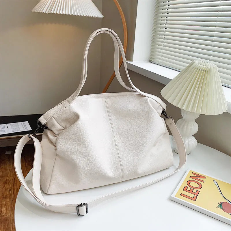 Large soft PU leather messenger bag in khaki colour with adjustable shoulder strap and top handle.