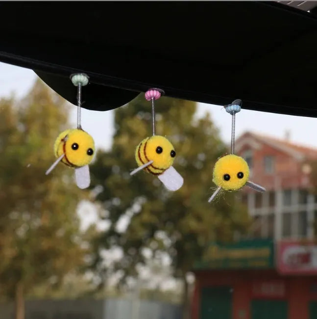 Spring-loaded bee car decoration with fur texture swinging from dashboard