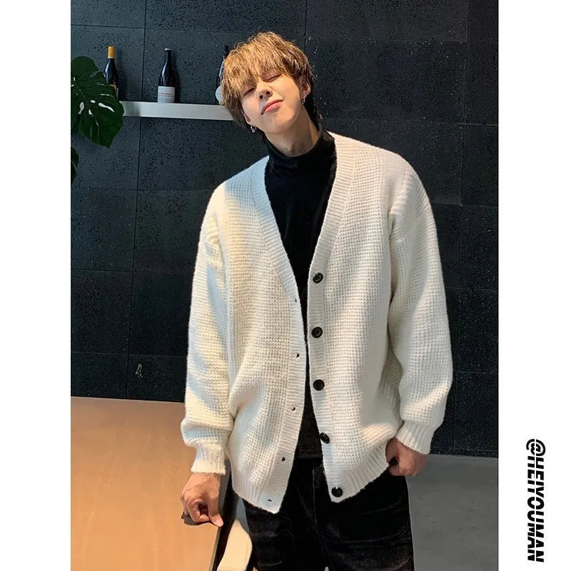 Men's loose fit V-neck knitted cardigan sweater in a solid colour on a hanger.
