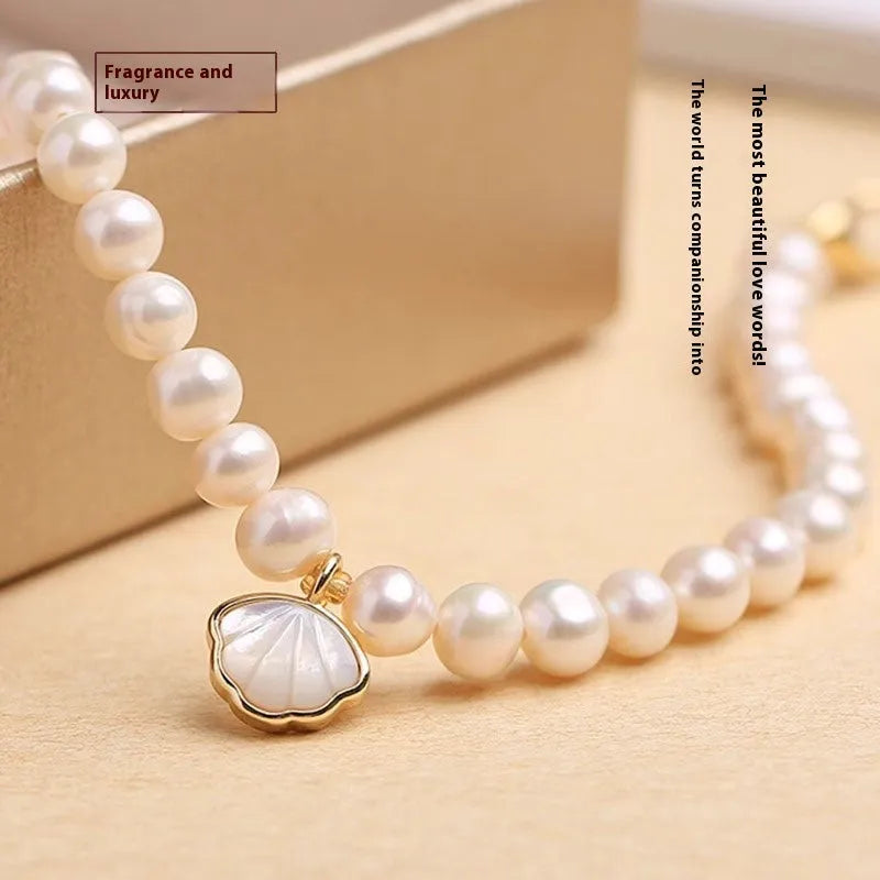 Women's freshwater pearl bracelet with fan-shell alloy clasp in 16cm size on wrist.