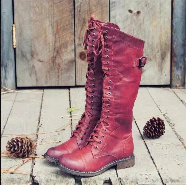 Women's black chunky heel high-leg boots with a round toe and low block heel on a plain background.