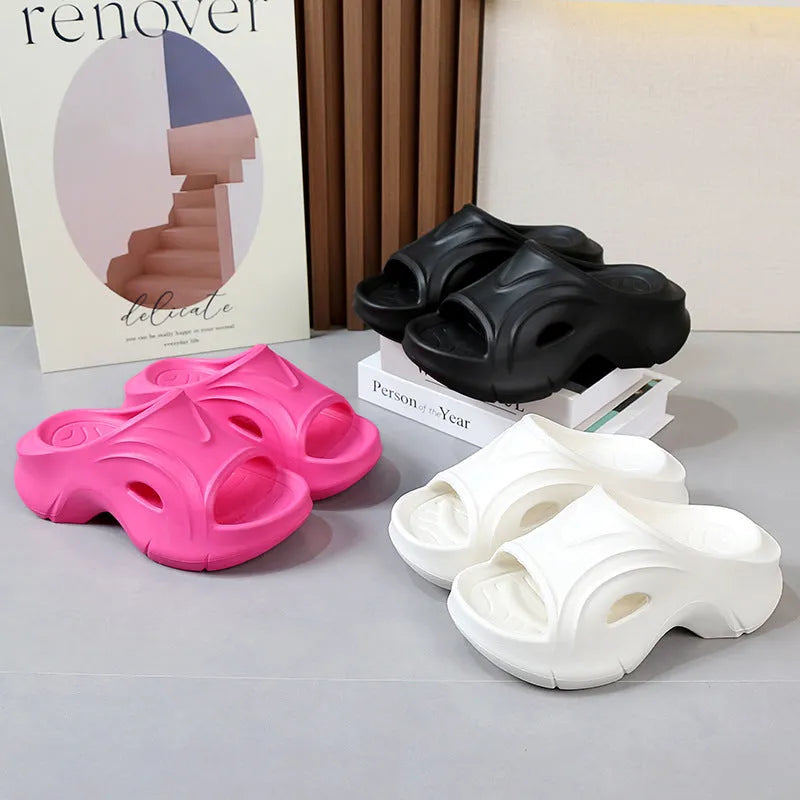 Women's thick-soled EVA slippers in rose red, shown on a beach background.