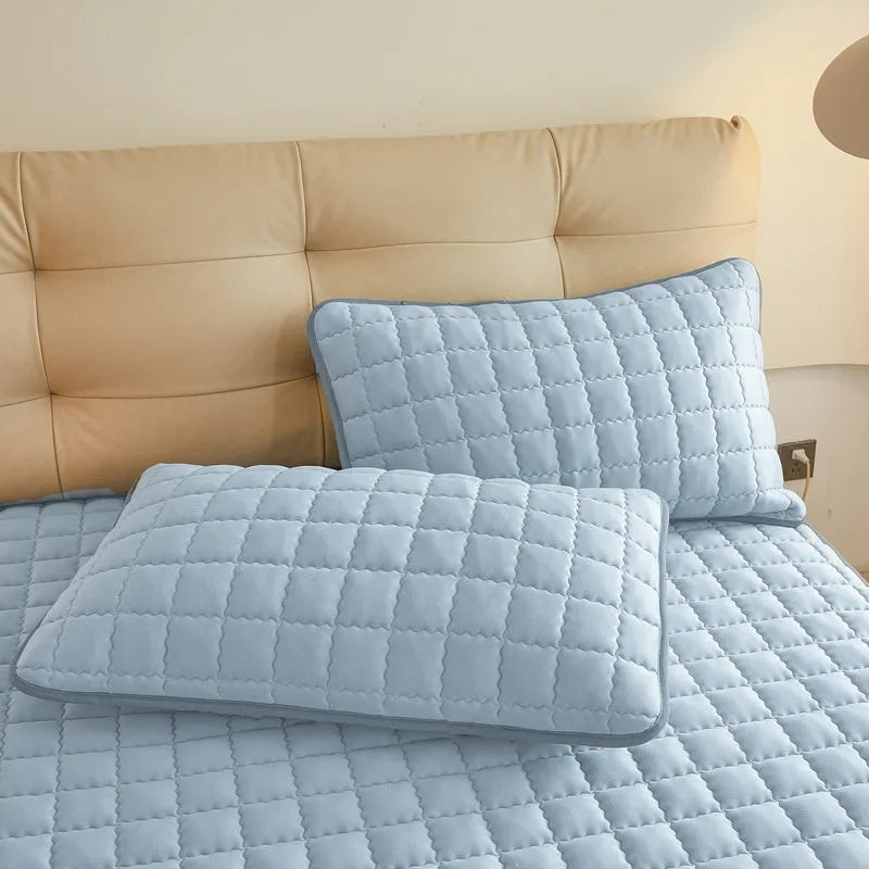 Blue waterproof washed cotton fitted sheet with elasticated edge on a mattress