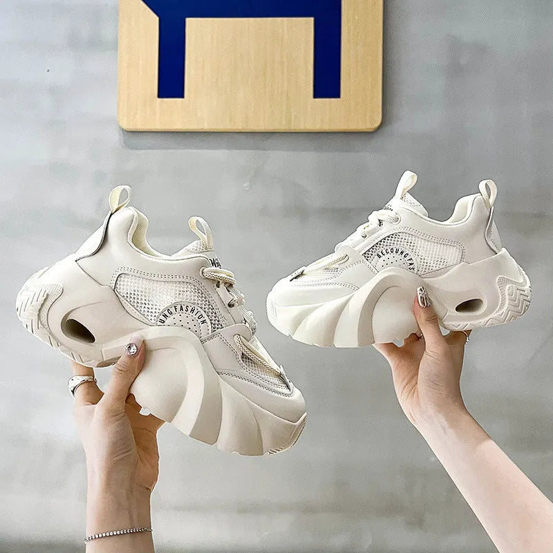 Women's beige platform sneakers with a cross-strap design and thick sole.