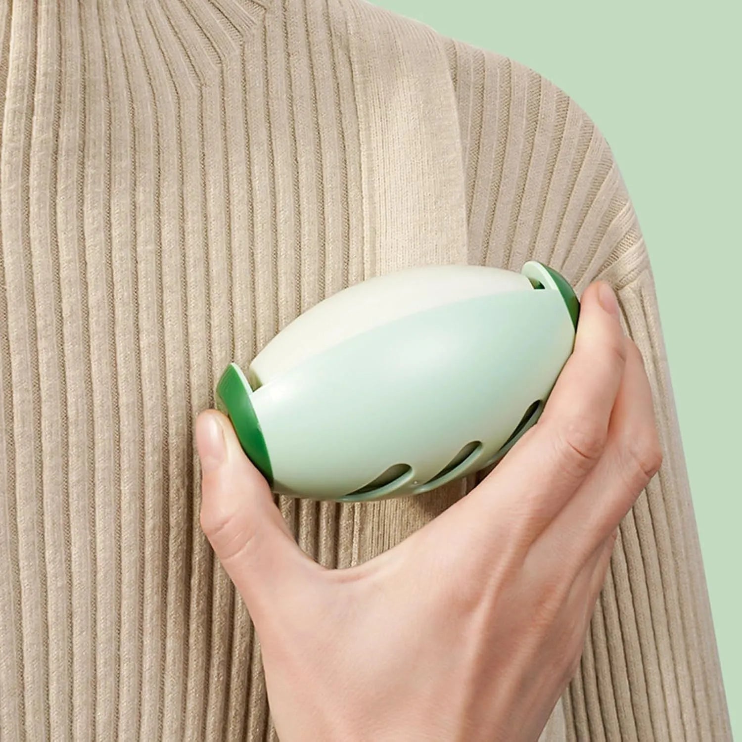 Green and white reusable gel lint roller ball for portable pet hair and lint removal.
