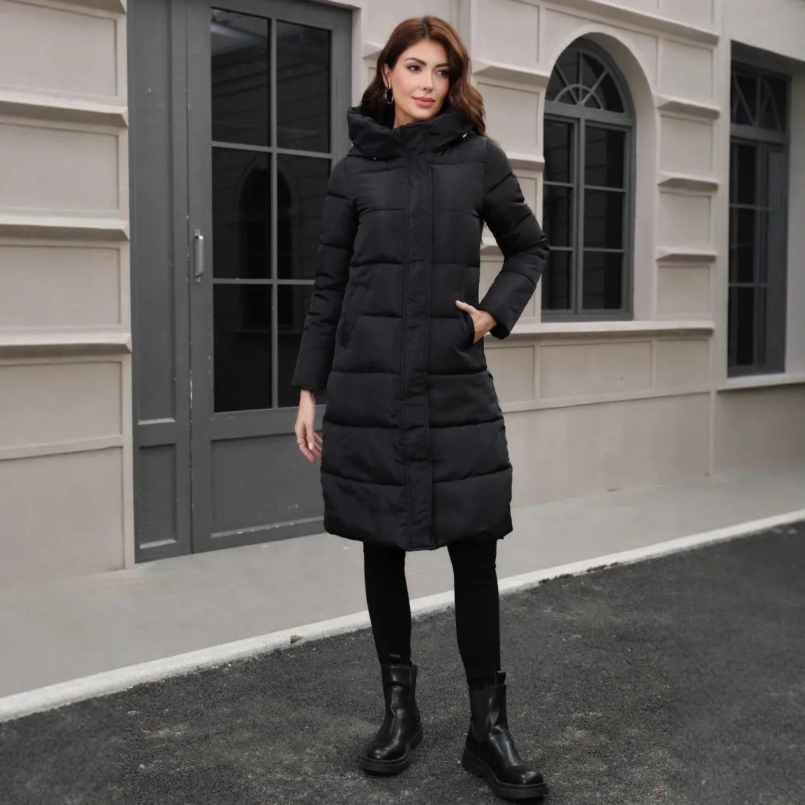 A black hooded slim-fit long jacket for men on a hanger.