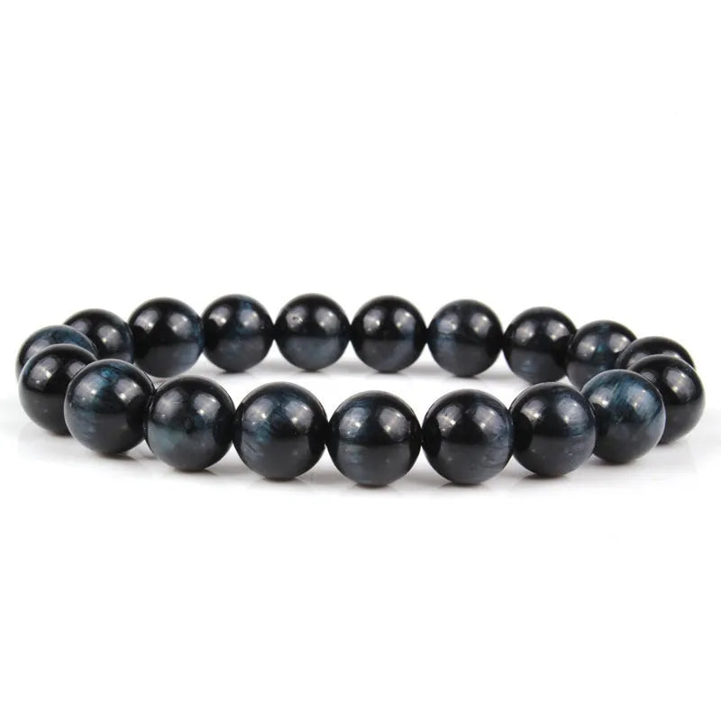 Tiger eye crystal stone bracelet showing round beads available in multiple colours and sizes on a wrist.
