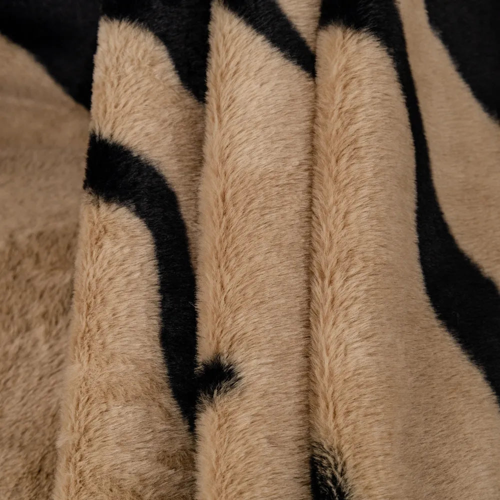Thickened flannel zebra pattern sofa cover in caramel or black draping over a sofa with non-slip texture visible
