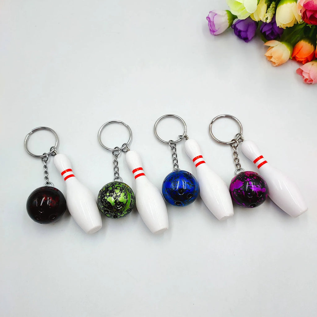 Mini sports bowling keychain pendant in PVC metal, shown in dark red, blue, purple, and green colour options.
