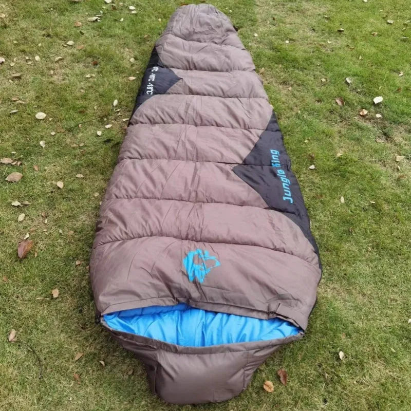 Outdoor cotton sleeping bag in Army Green with its compression storage sack laid beside it.