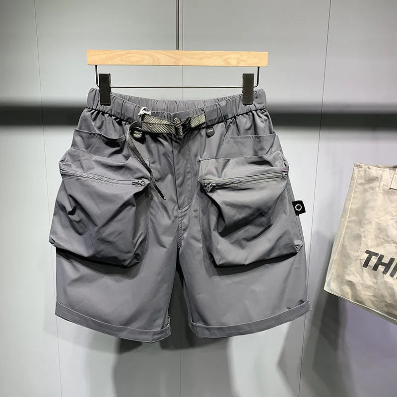 Man wearing loose fit black workwear shorts with pockets, showing above-the-knee length and straight leg style.