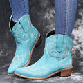 Blue women's cowboy ankle boots with embroidery, a pointed toe, and a low wedge heel.