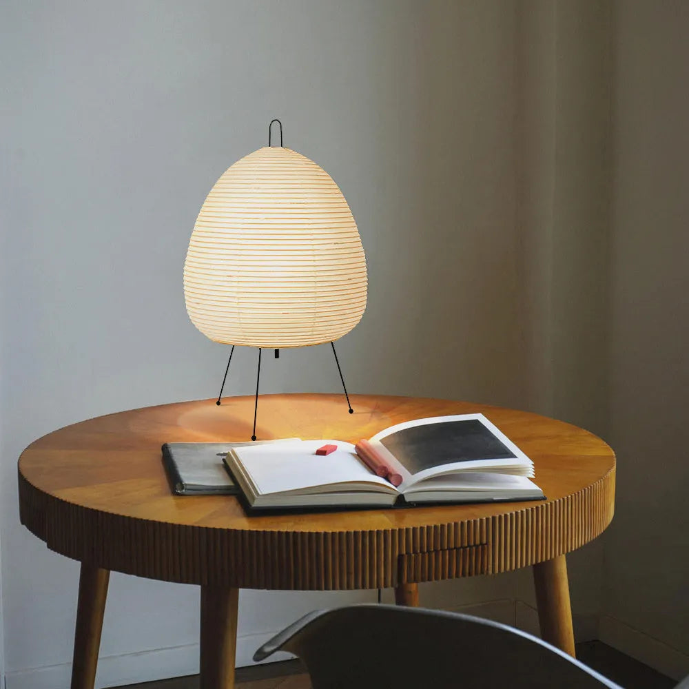 Japanese style rice paper table lamp with aluminium body and decorative shade on wooden surface