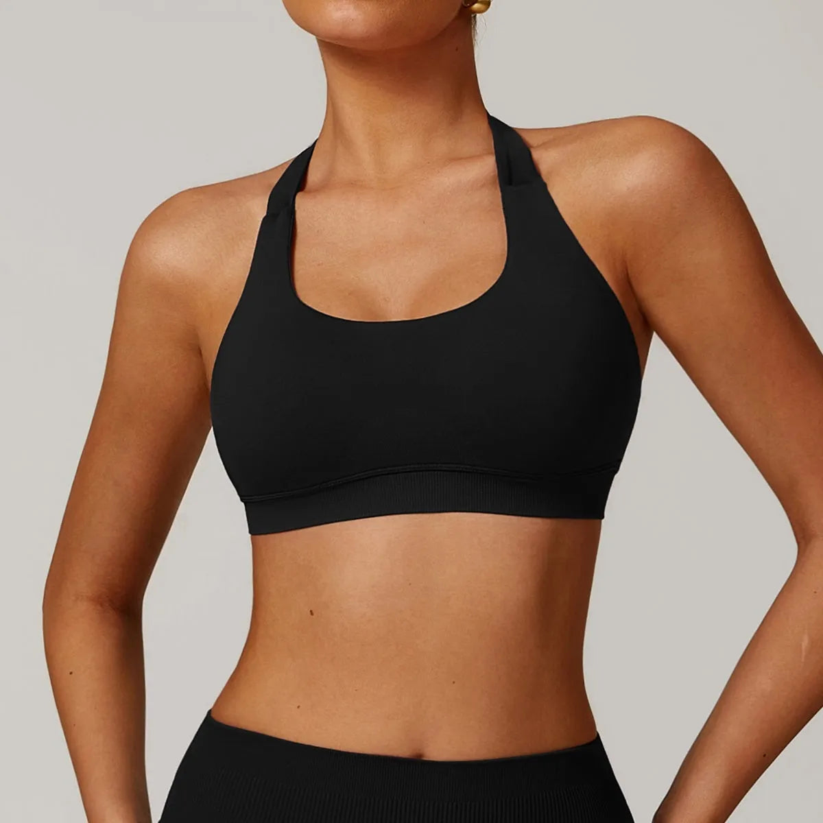 Women's black halter neck nylon sports bra for yoga and workouts on a mannequin.