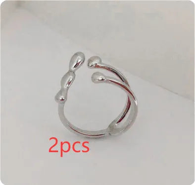 Gold or silver brass opening ring with spherical design elements on a model's finger.