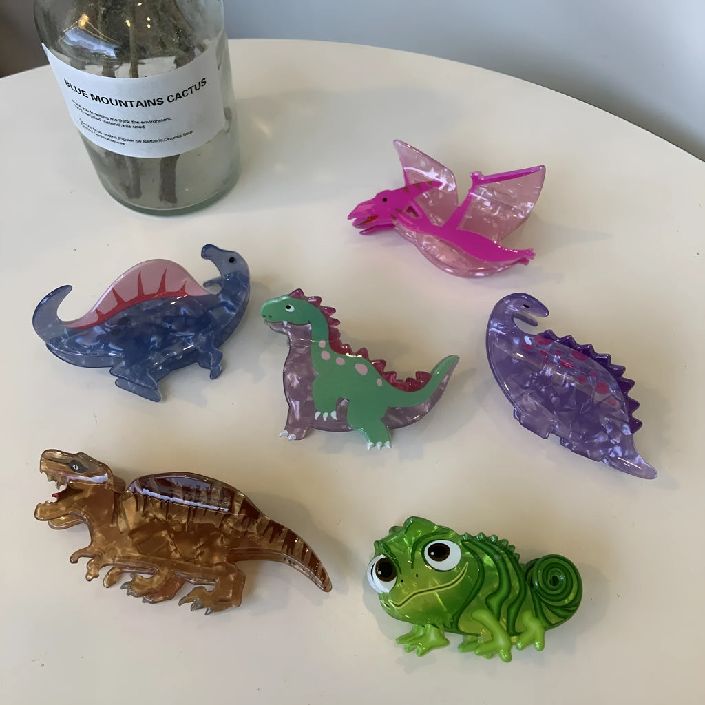 A colourful acrylic jaw clip hair grip featuring a detailed little dinosaur design.