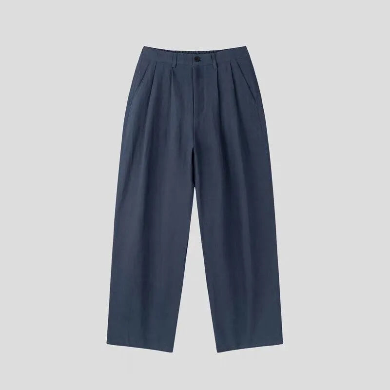 Men's lightweight apricot coloured wide-leg cotton linen trousers with a pencil leg opening on a hanger