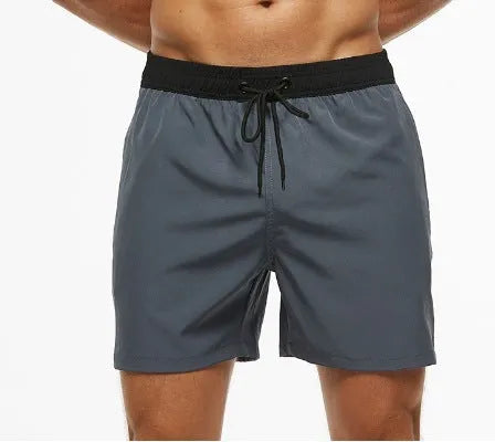 Men's blue drawstring athletic shorts with a zipper pocket and stitching detail on the waistband