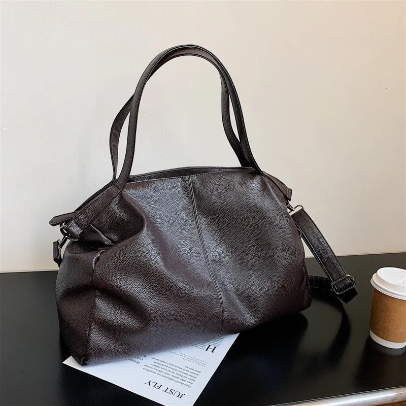 Large soft PU leather messenger bag in khaki colour with adjustable shoulder strap and top handle.