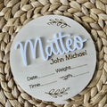 Square 15cm wooden baby name plaque with birth details displayed, shown in three style options.