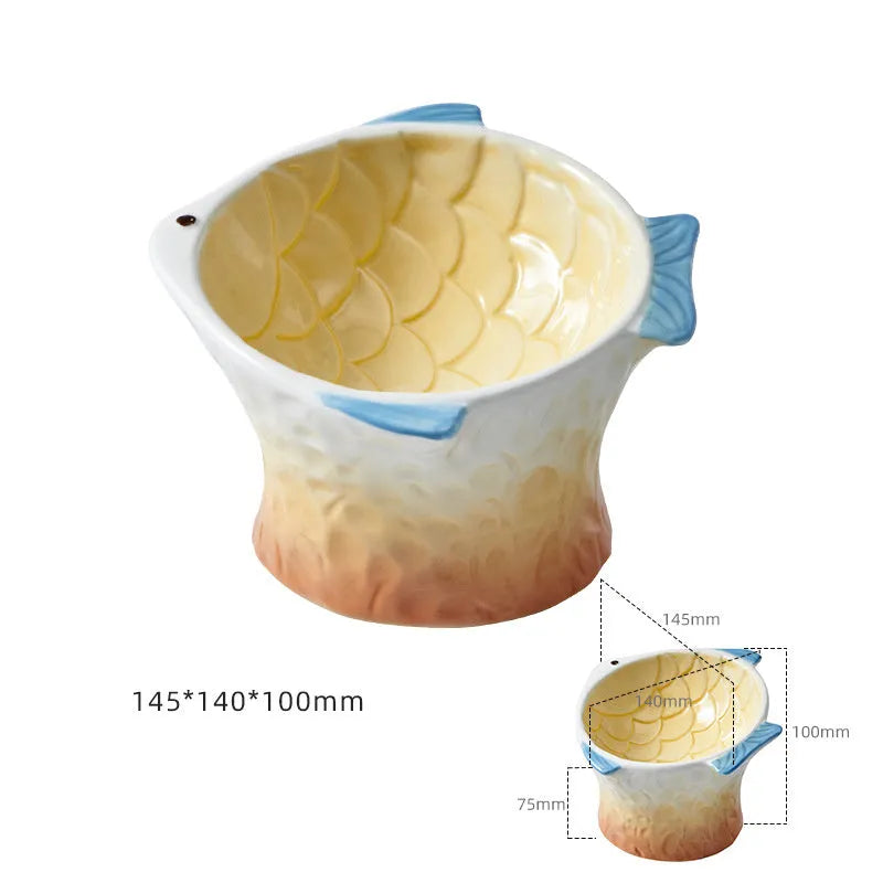 Blue ceramic fish-shaped cat bowl with tilted design and shallow eating surface on a plain background.